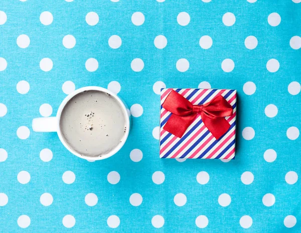 Cup of coffee and cute gift — Stock Photo, Image