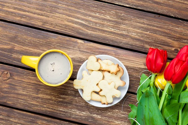 Куча тюльпанов с тарелкой печенья — стоковое фото