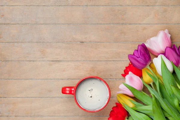 Kopje koffie met kleurrijke tulpen — Stockfoto