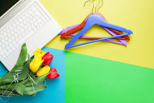 Bunch of tulips, laptop and hangers — Stock Photo, Image