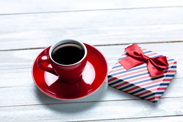 Cup of coffee and cute wrapped gift — Stock Photo, Image