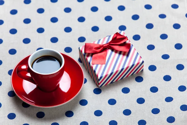 Cup of coffee and cute wrapped gift — Stock Photo, Image