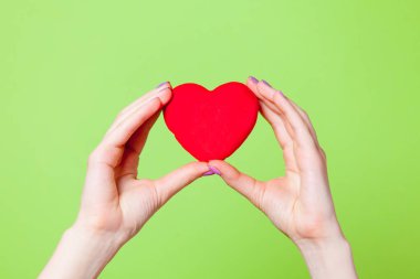 kalp şekilli oyuncak ile eller