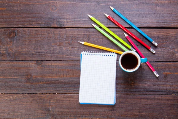 Notebook with pencils and cup of coffee — Stock Photo, Image