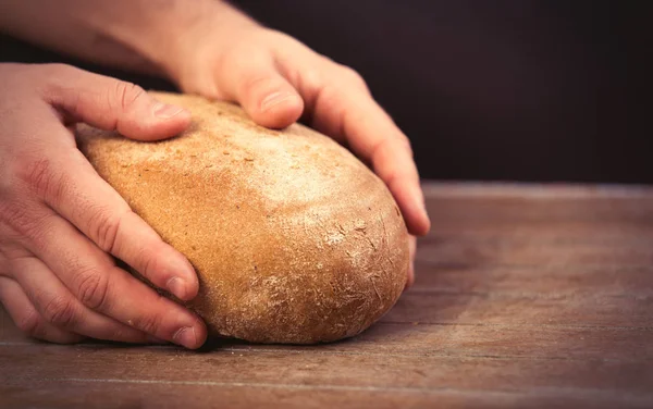 Male hands holding bread loaf — Stock Photo, Image