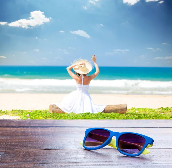 Zonnebril op de jonge vrouw aan de kust — Stockfoto