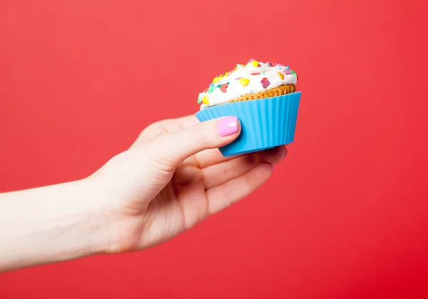 Vrouwelijke hand bedrijf cupcake — Stockfoto