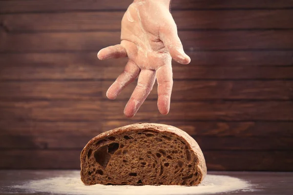 Male hand over bread loaf — Stock Photo, Image