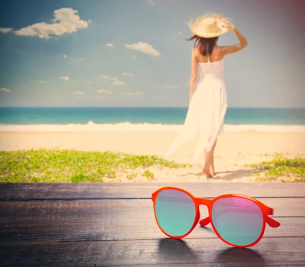 Zonnebril op de jonge vrouw aan de kust — Stockfoto