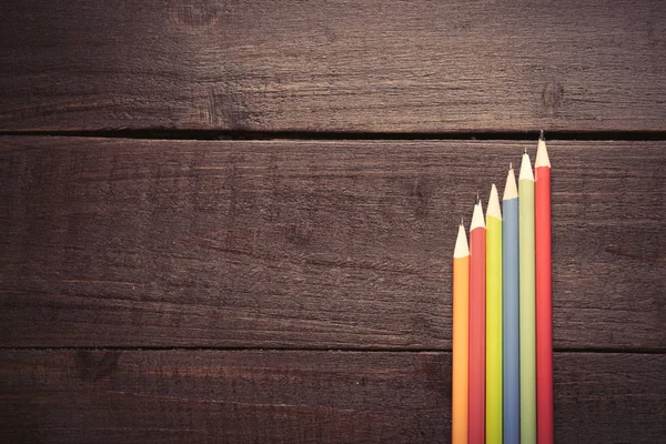 Kolorowe ołówki na drewnianym tle — Zdjęcie stockowe