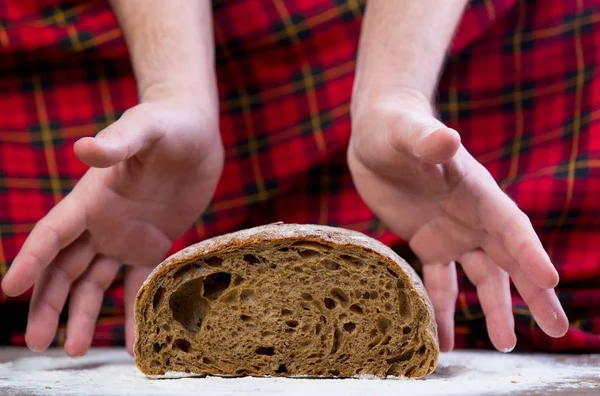 Male hands over bread loaf — Stock Photo, Image