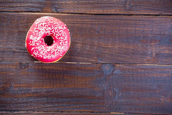 Saboroso donut envidraçado no fundo de madeira — Fotografia de Stock