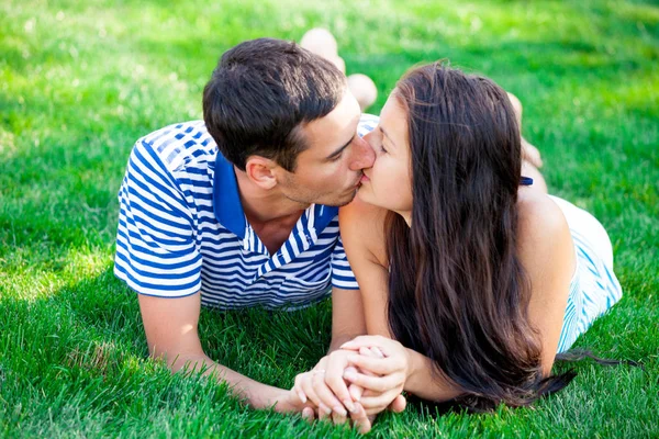 Couple baisers et couché sur l'herbe — Photo