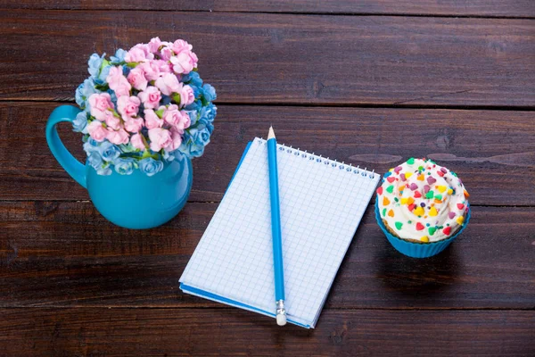 Notebook ołówek, kwiaty i ciastko — Zdjęcie stockowe