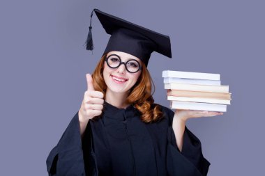 güzel genç mezunu wonde kitap yığını ile fotoğrafı