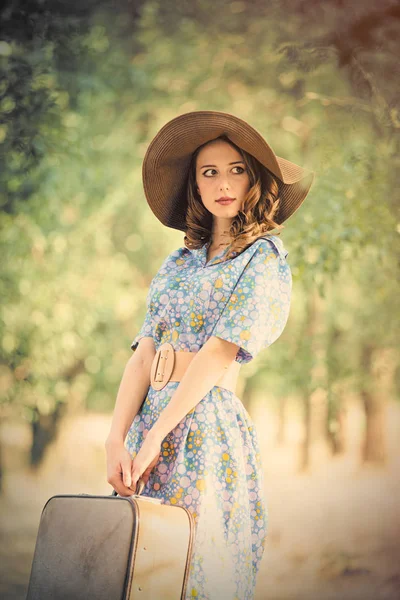 Fotografie z krásné mladé ženy s kufrem na nádherné tr — Stock fotografie