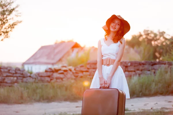 Фото красивой молодой женщины с чемоданом на чудесном пляже — стоковое фото