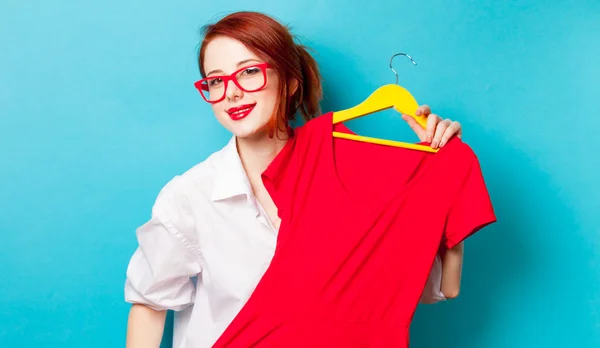 Foto av vackra unga kvinna som håller skjortan på hängare på wo — Stockfoto