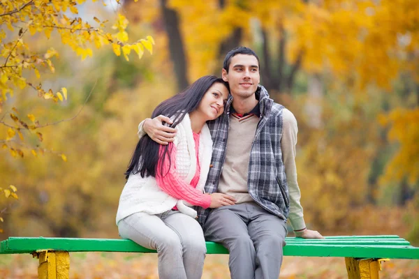 Foto de una linda pareja sentada en el banco en el maravilloso autum —  Fotos de Stock