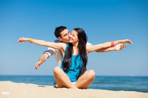 可爱的夫妇坐在沙滩上和在韩元上接吻的照片 — 图库照片