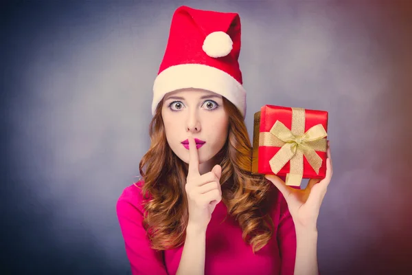 Foto van mooie jonge vrouw in Kerstman hoed met leuke cadeau — Stockfoto