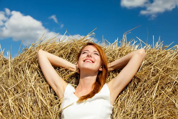 干し草の上に横たわると t に笑顔の美しい若い女性の写真 — ストック写真