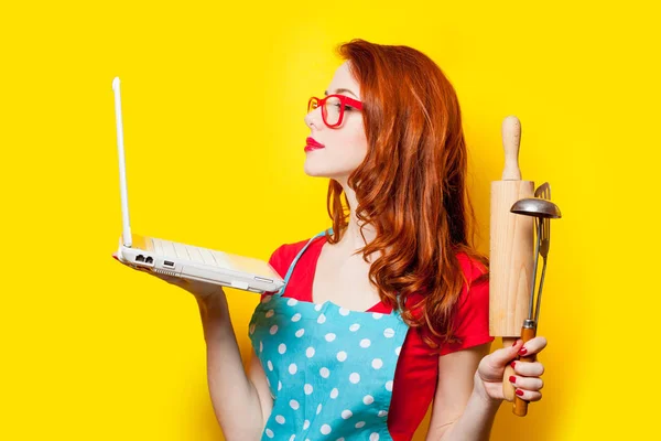 Foto de bela jovem com equipamento de cozinha e laptop — Fotografia de Stock