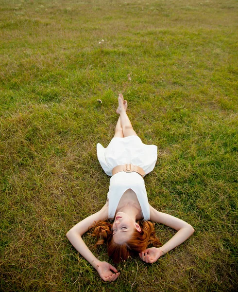 Foto de bela jovem deitada no campo e relaxante — Fotografia de Stock