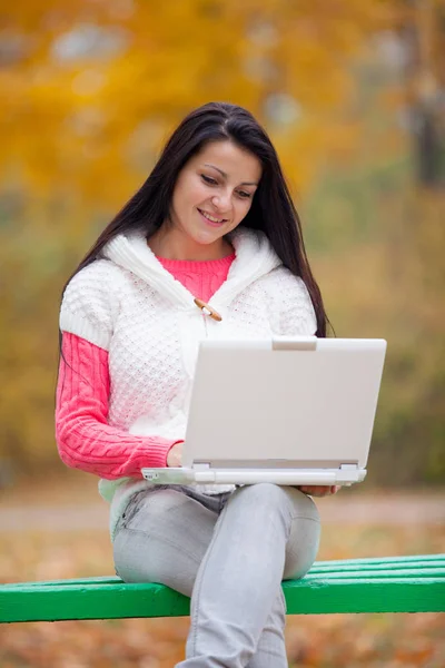 Gyönyörű fiatal nő ül a padon, laptop fénykép — Stock Fotó