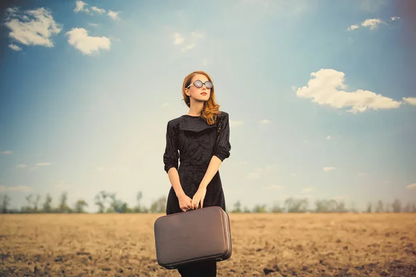 Photo of beautiful young woman with suitcase on the wonderful fi — Stock Photo, Image
