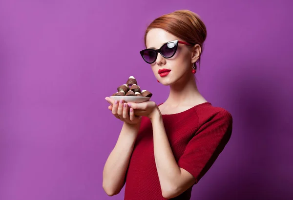 Foto de la hermosa mujer joven con el plato lleno de chocolate cand —  Fotos de Stock