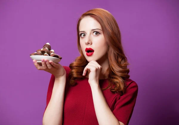 Foto de la hermosa mujer joven con el plato lleno de chocolate cand —  Fotos de Stock