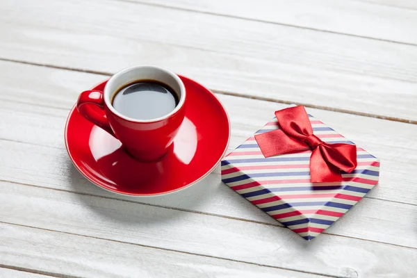 Zdjęcie z czerwony kubek kawy i ładny prezent na dobry biały — Zdjęcie stockowe
