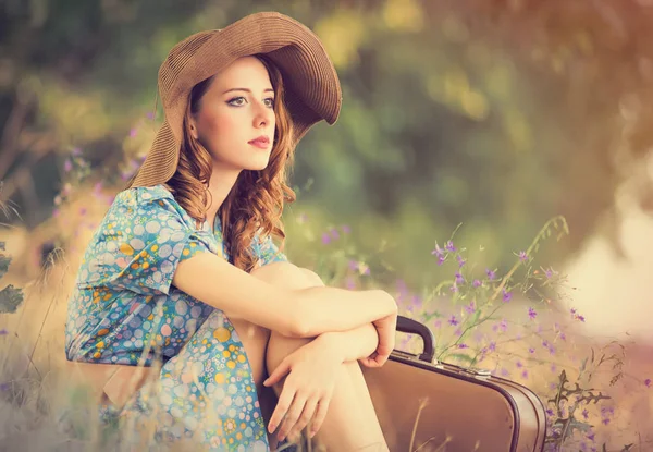 スーツケース、フォアグラの上に座って、美しい若い女性の写真 — ストック写真