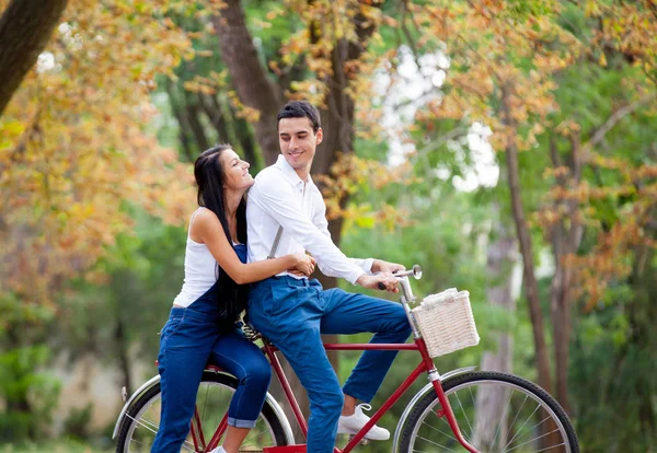 Φωτογραφία από το χαριτωμένο ζευγάρι κάθεται στο ποδήλατο και αγκάλιασμα για τα σάουντρακ των ται — Φωτογραφία Αρχείου