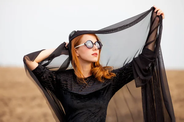 Photo of beautiful young woman holding shawl on the wonderful fi — Stock Photo, Image