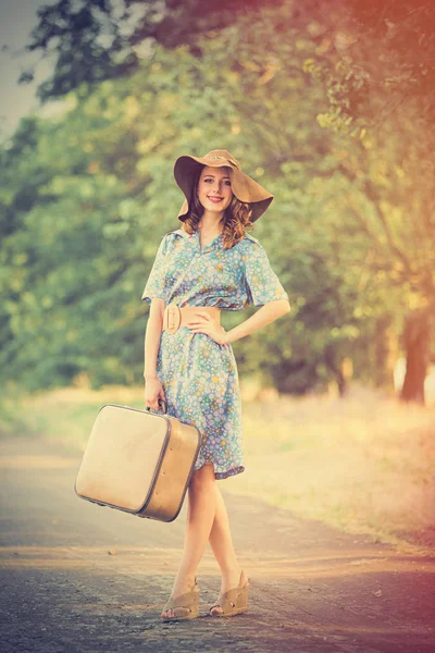 Photo de belle jeune femme avec valise debout sur le roa — Photo