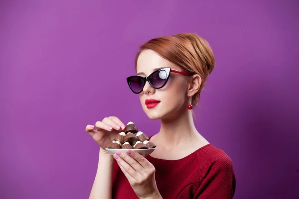 Foto de bela jovem com placa cheia de chocolate cand — Fotografia de Stock