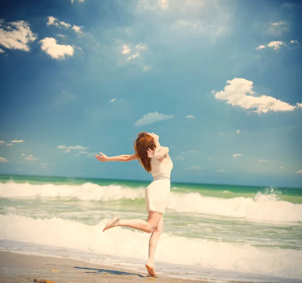 Foto van mooie jonge vrouw springen op de zonnige kust op de — Stockfoto