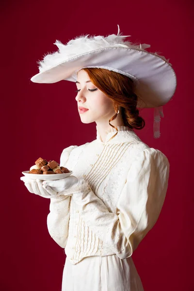 Foto de hermosa mujer joven en vestido vintage con plato lleno —  Fotos de Stock