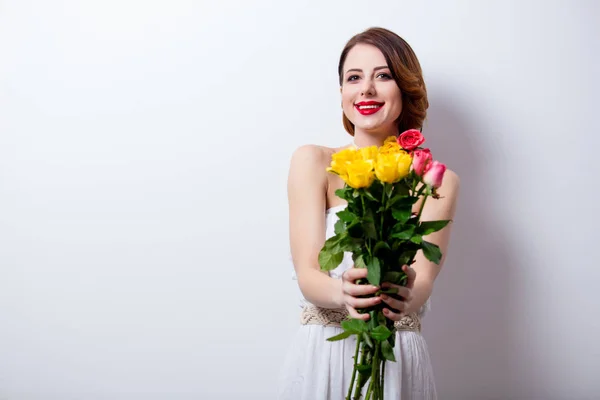 Beautiful young woman with bouquet of roses — Stock Photo, Image
