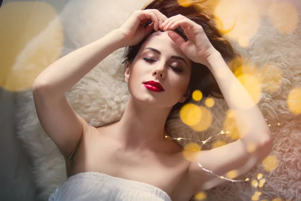 Beautiful young woman lying on blanket — Stock Photo, Image