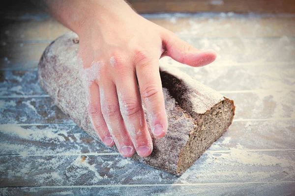 Hand touching fresh bread — Stock Photo, Image