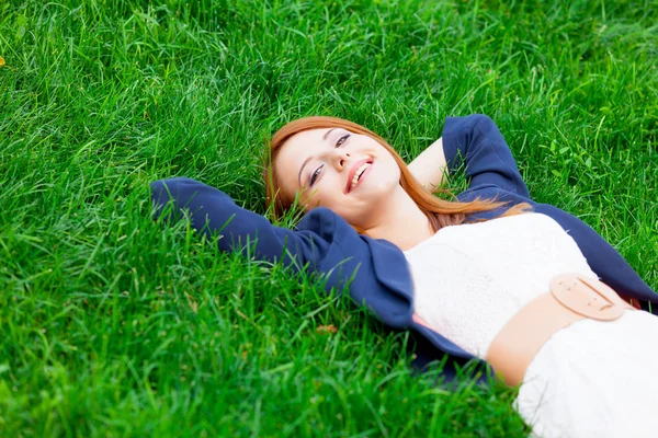 Güzel genç bir kadın çimenlerde yatıyor. — Stok fotoğraf