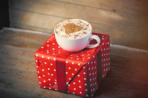 Cute gift and cup of coffee — Stock Photo, Image