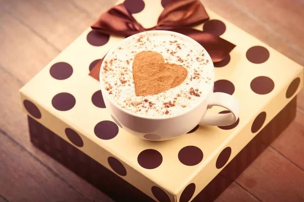 Šálek kávy a roztomilý dárek — Stock fotografie