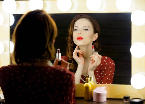 Beautiful young woman holding lipstick — Stock Photo, Image