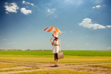 bavul ve şemsiye ile güzel genç kadın