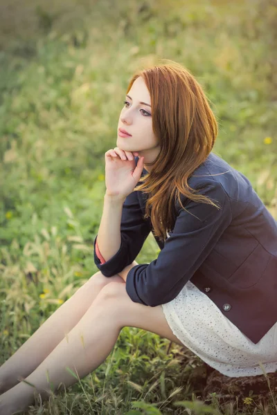 Mooie jonge vrouw zitten op gras — Stockfoto