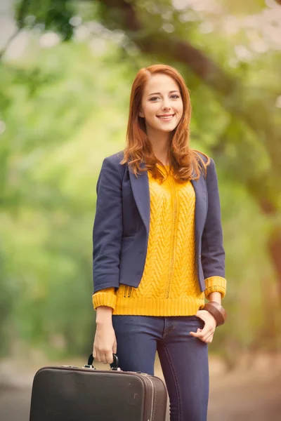 Mooie jonge vrouw met koffer — Stockfoto